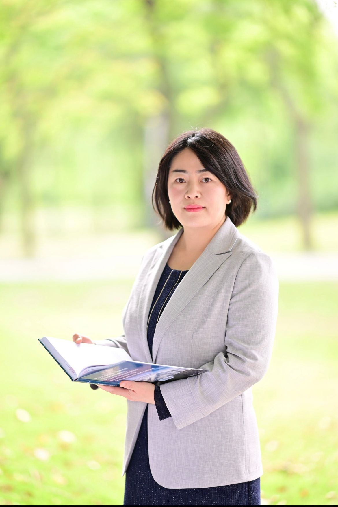 穿黑色衣服的女人在草地上描述已自动生成 穿黑色衣服的女人在草地上描述已自动生成